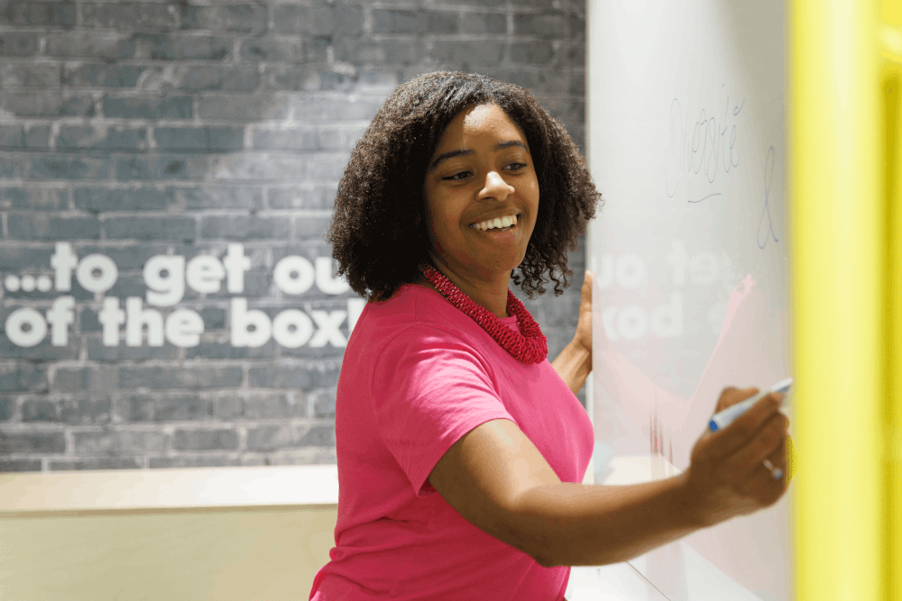 a woman writing on a whiteboard