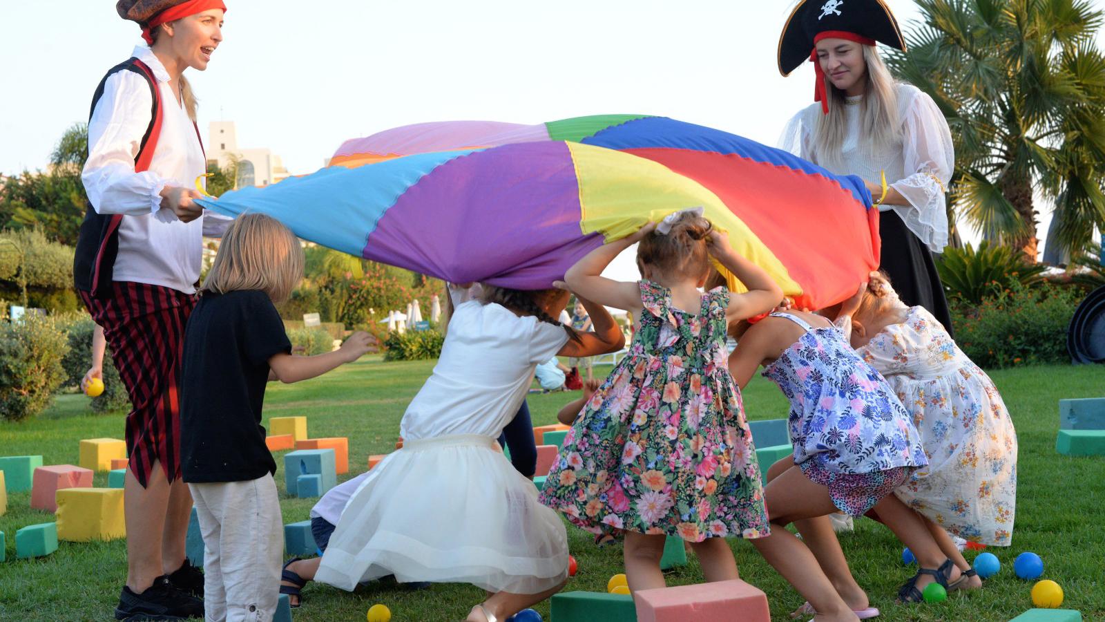 a group of children playing with a large parachute