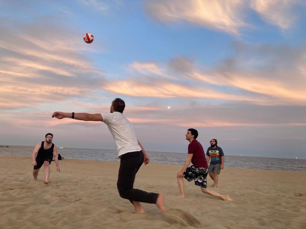 a group of people playing with a ball on a beach