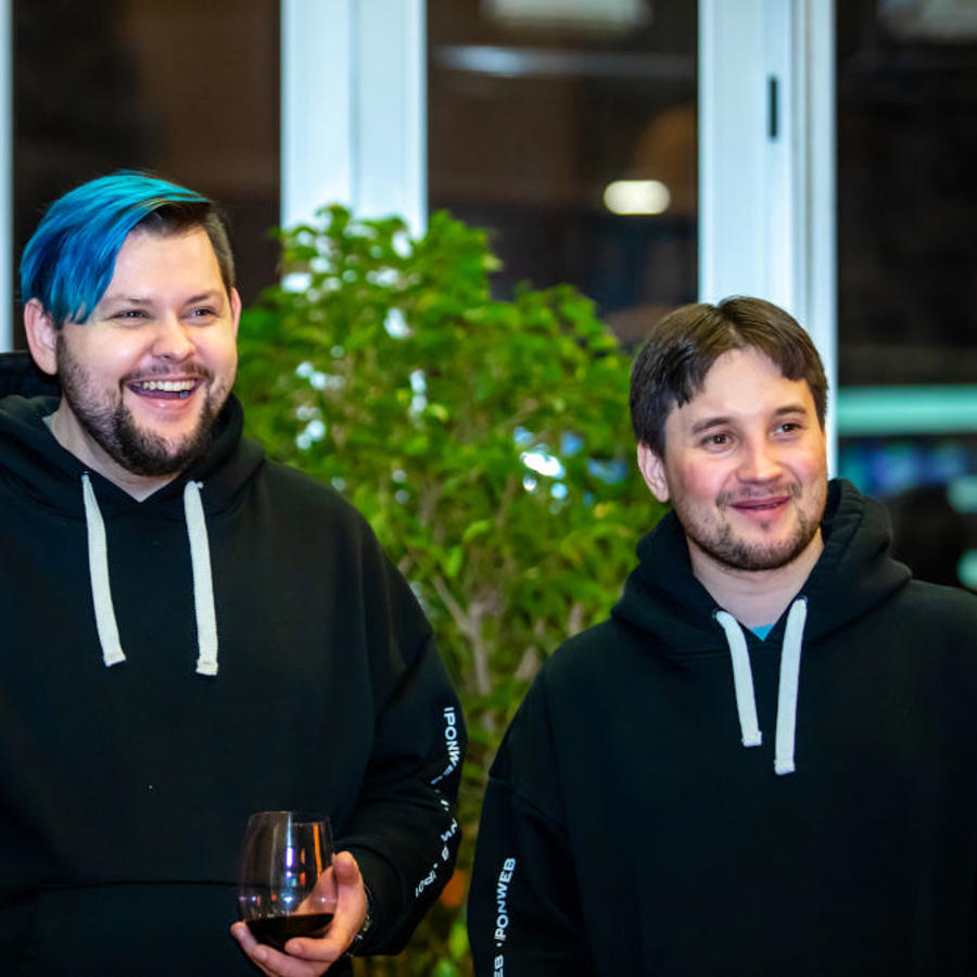 a couple of men smiling and holding a glass of wine