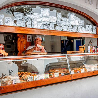 a man behind a counter with food in a window