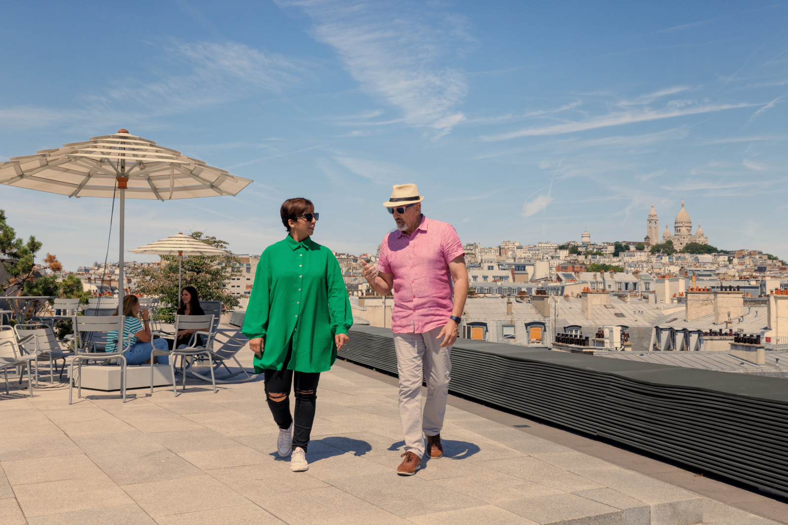 a man and woman walking on a rooftop
