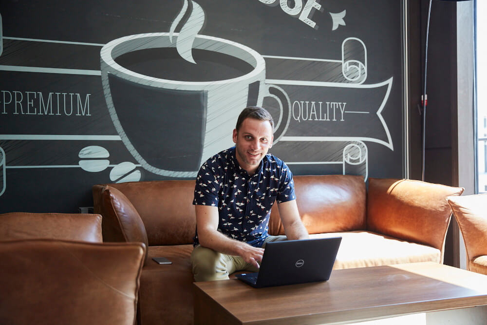 a man sitting on a couch using a laptop