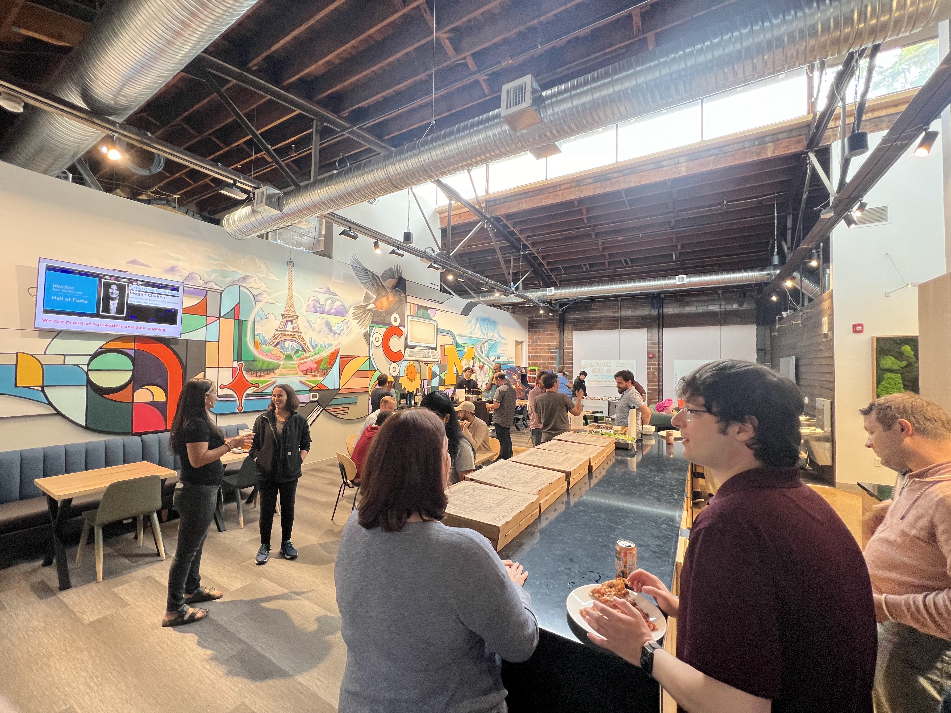 a group of people in a room with a large wall and a large ceiling