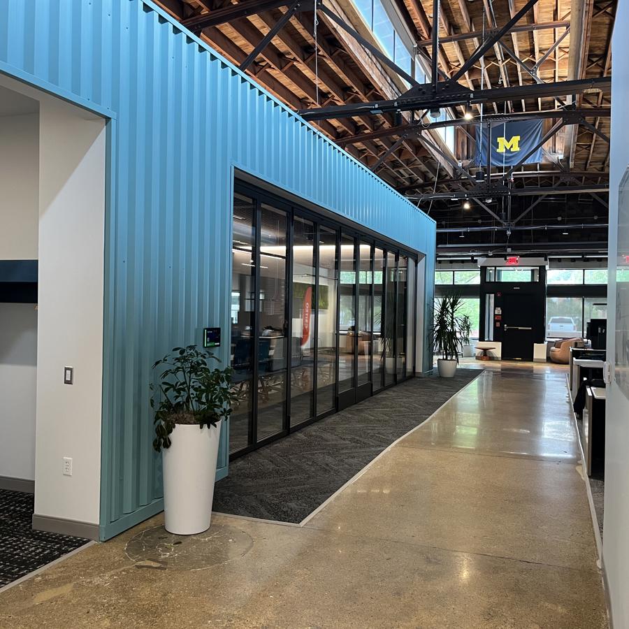 a hallway with a blue wall and a planter