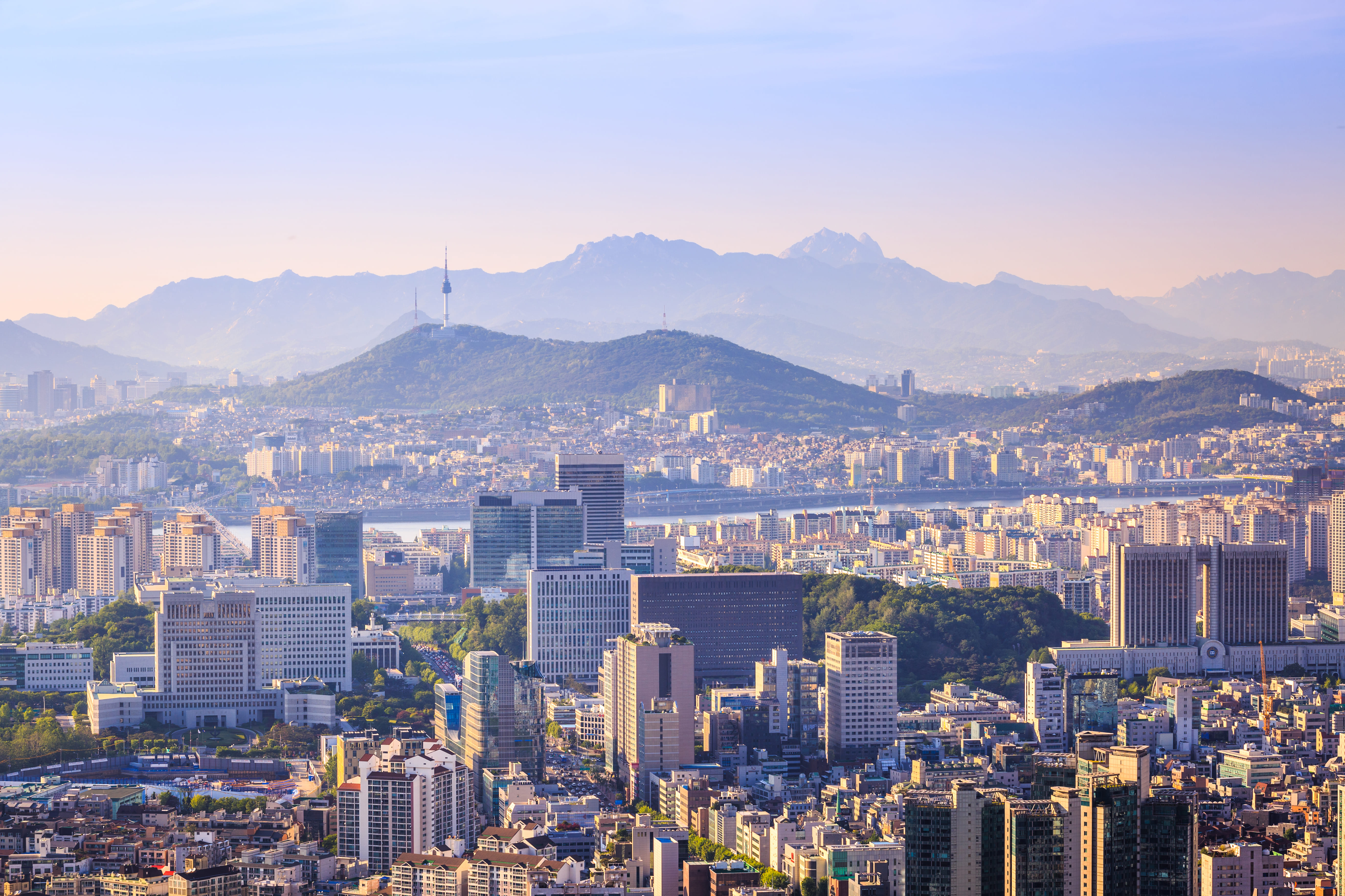 a city with many tall buildings and mountains in the background