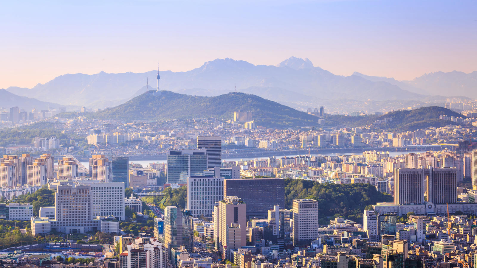 a city with many tall buildings and mountains in the background
