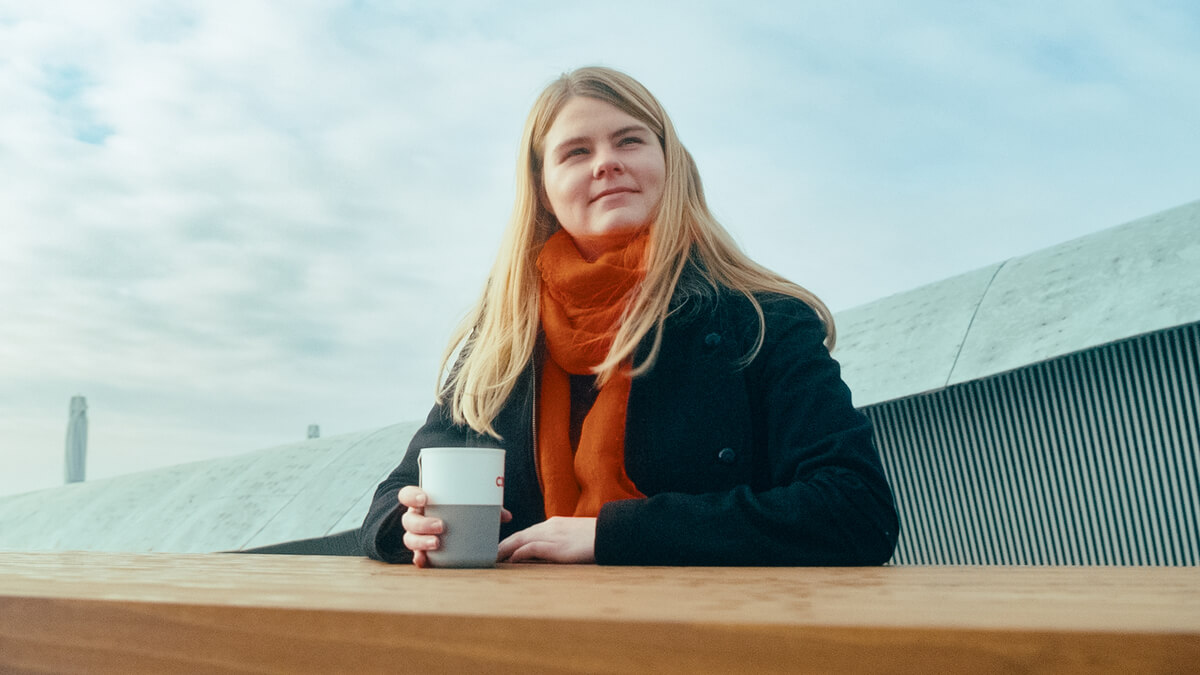 a woman sitting at a table holding a cup