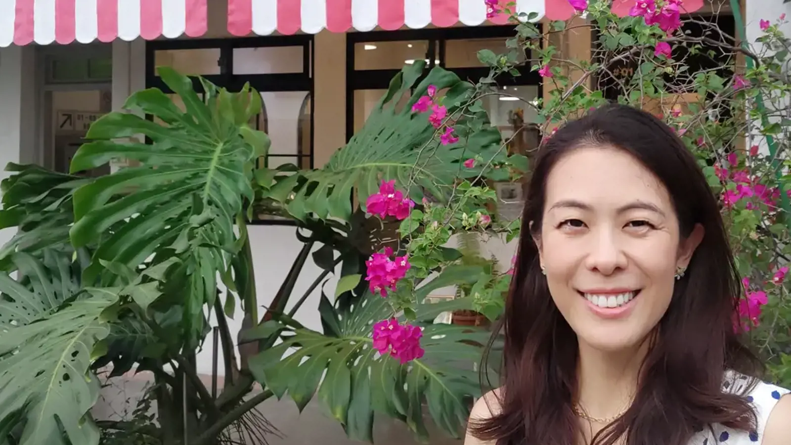 a woman smiling in front of a building