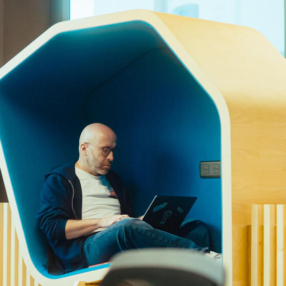 a man sitting in a chair with a laptop