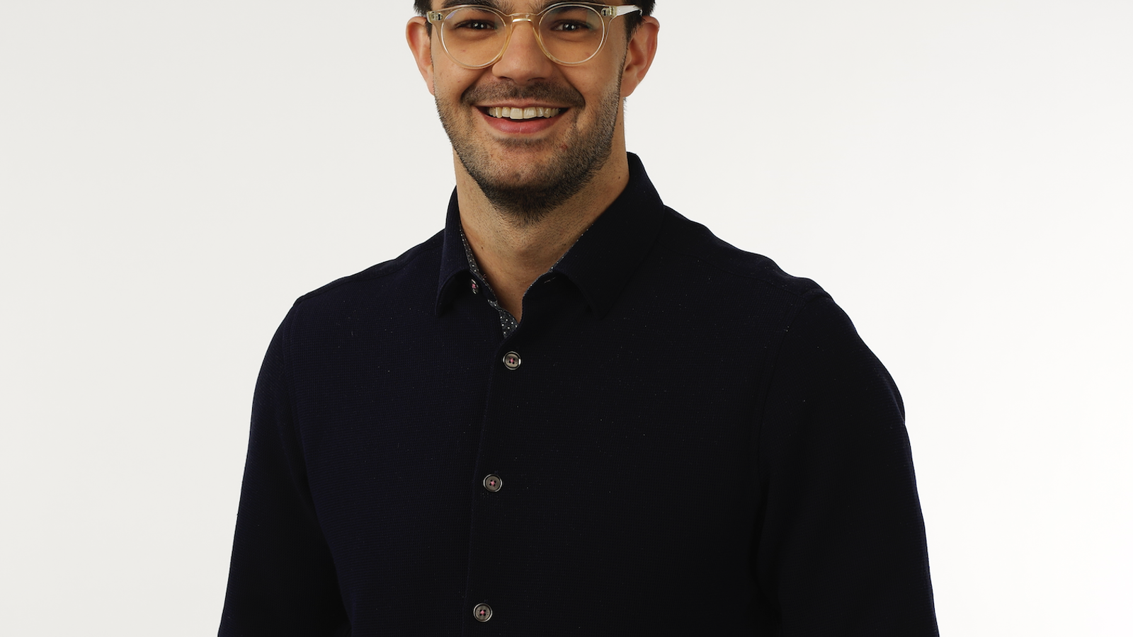 a man wearing glasses and smiling