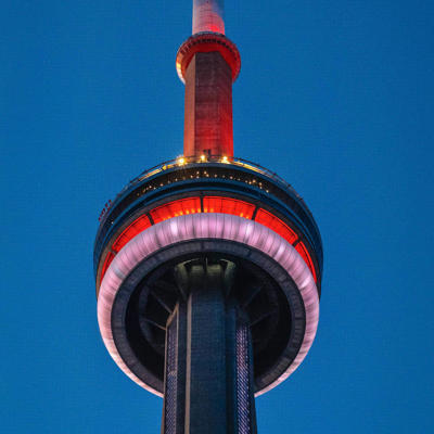 a tall tower with a white and red light with CN Tower in the background