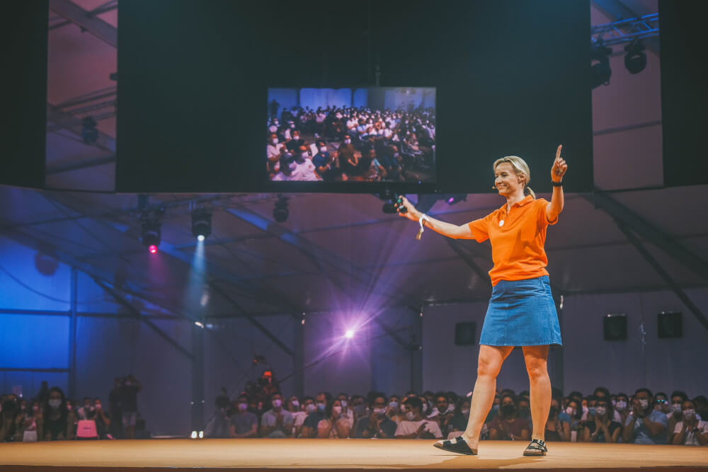 a woman on stage with a crowd watching