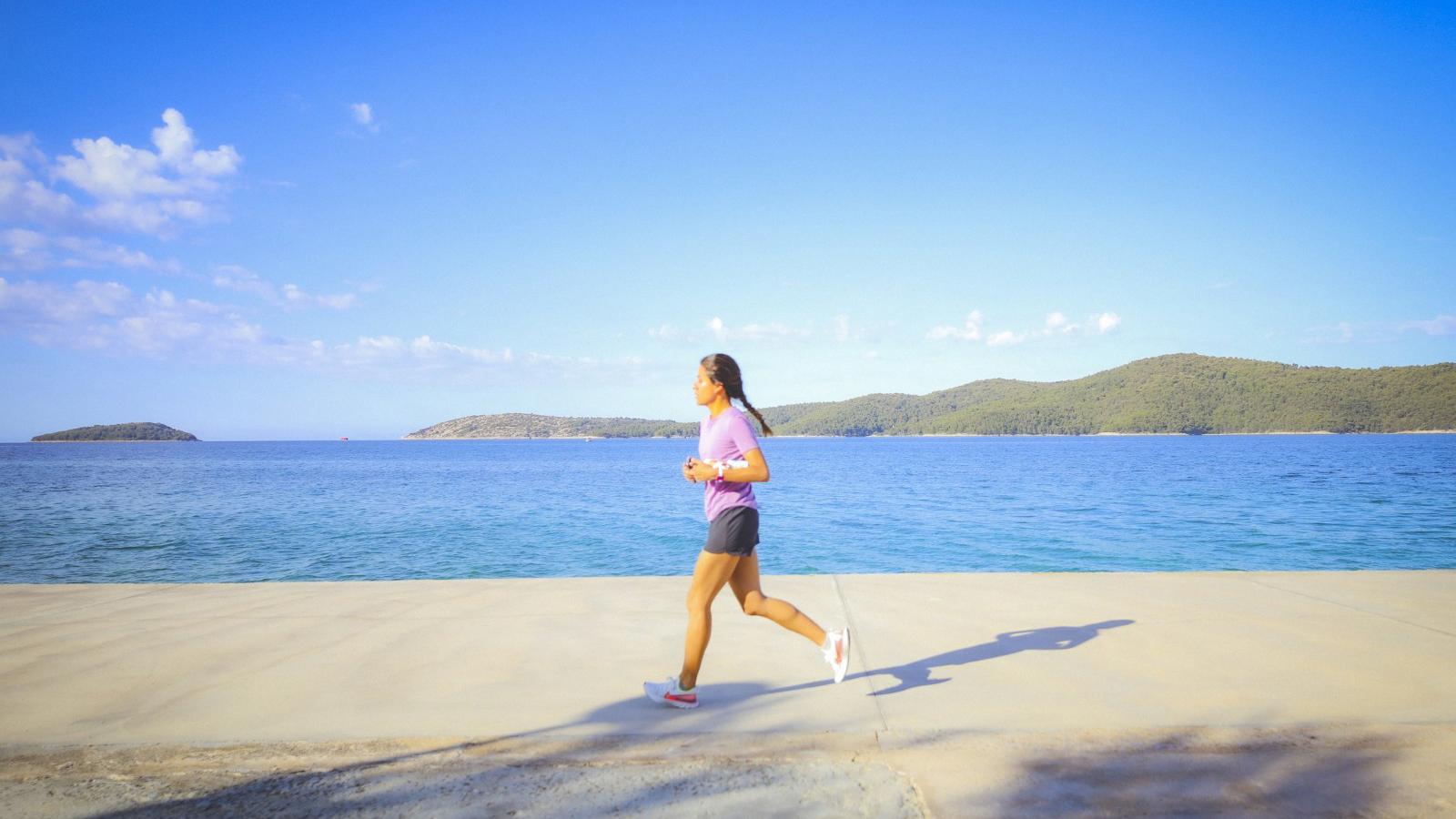 a woman running near water