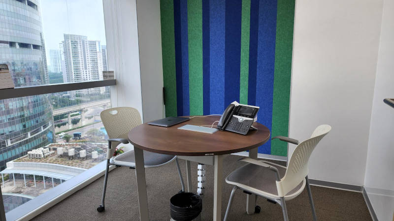 a table with chairs and a laptop