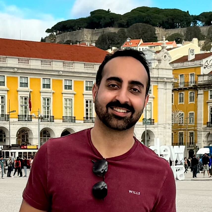 a man smiling in front of a building