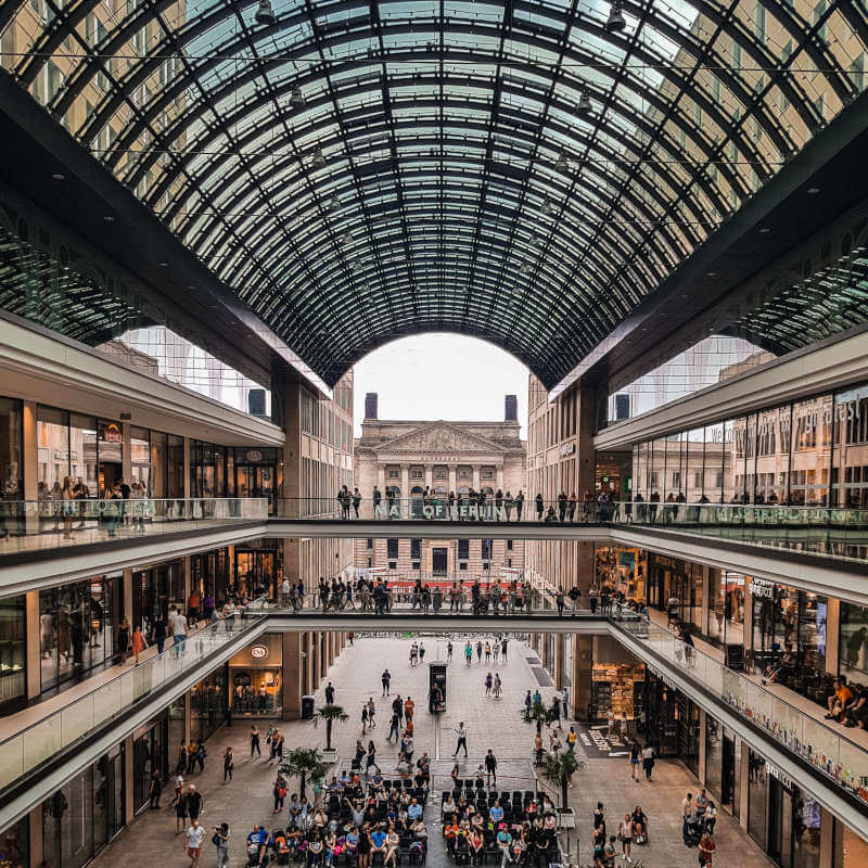 a large glass building with many people