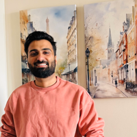 a man smiling in front of a painting
