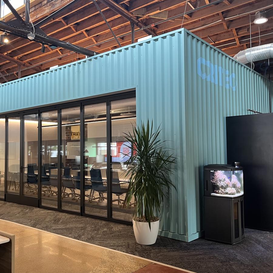 a building with a glass wall and a plant