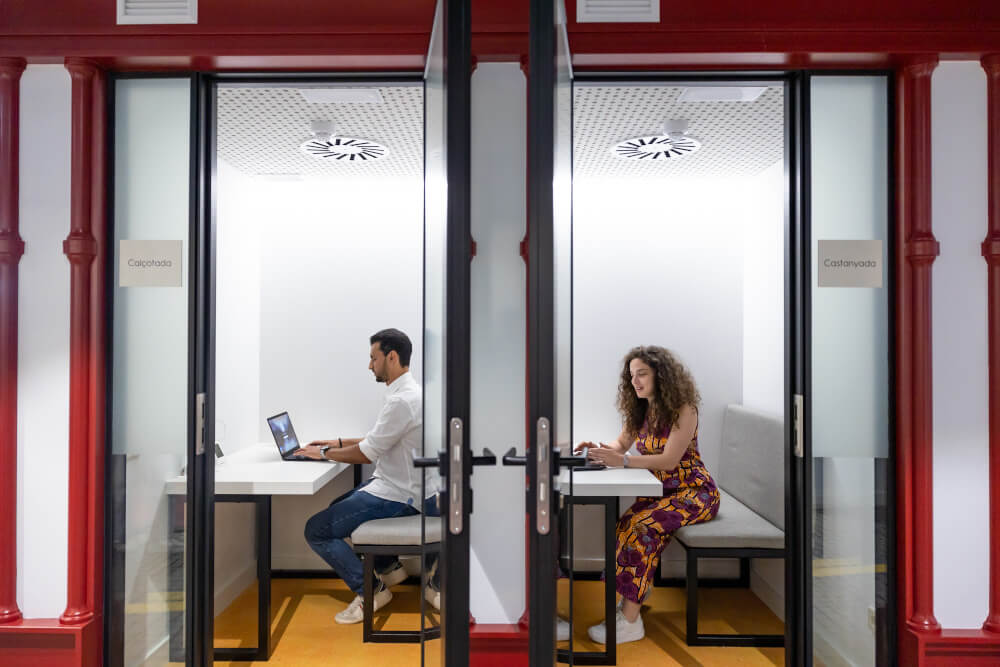 a man and woman sitting at a table with a laptop