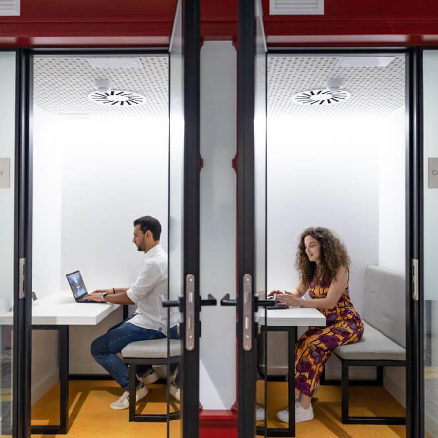 a man and woman sitting at a table with a laptop