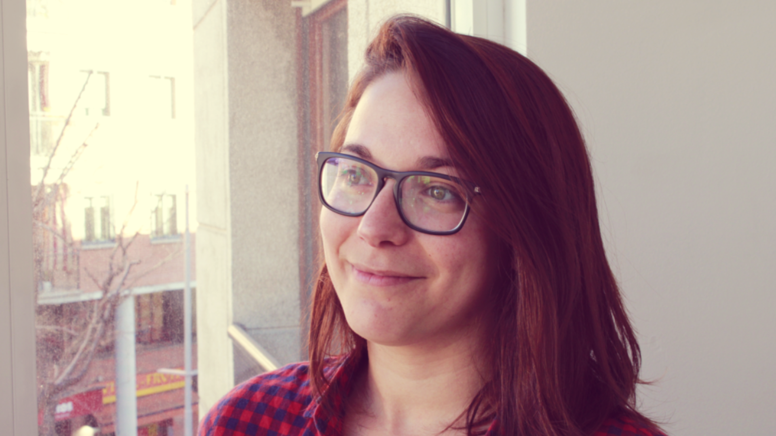 a woman wearing glasses and smiling