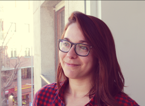 a woman wearing glasses and smiling