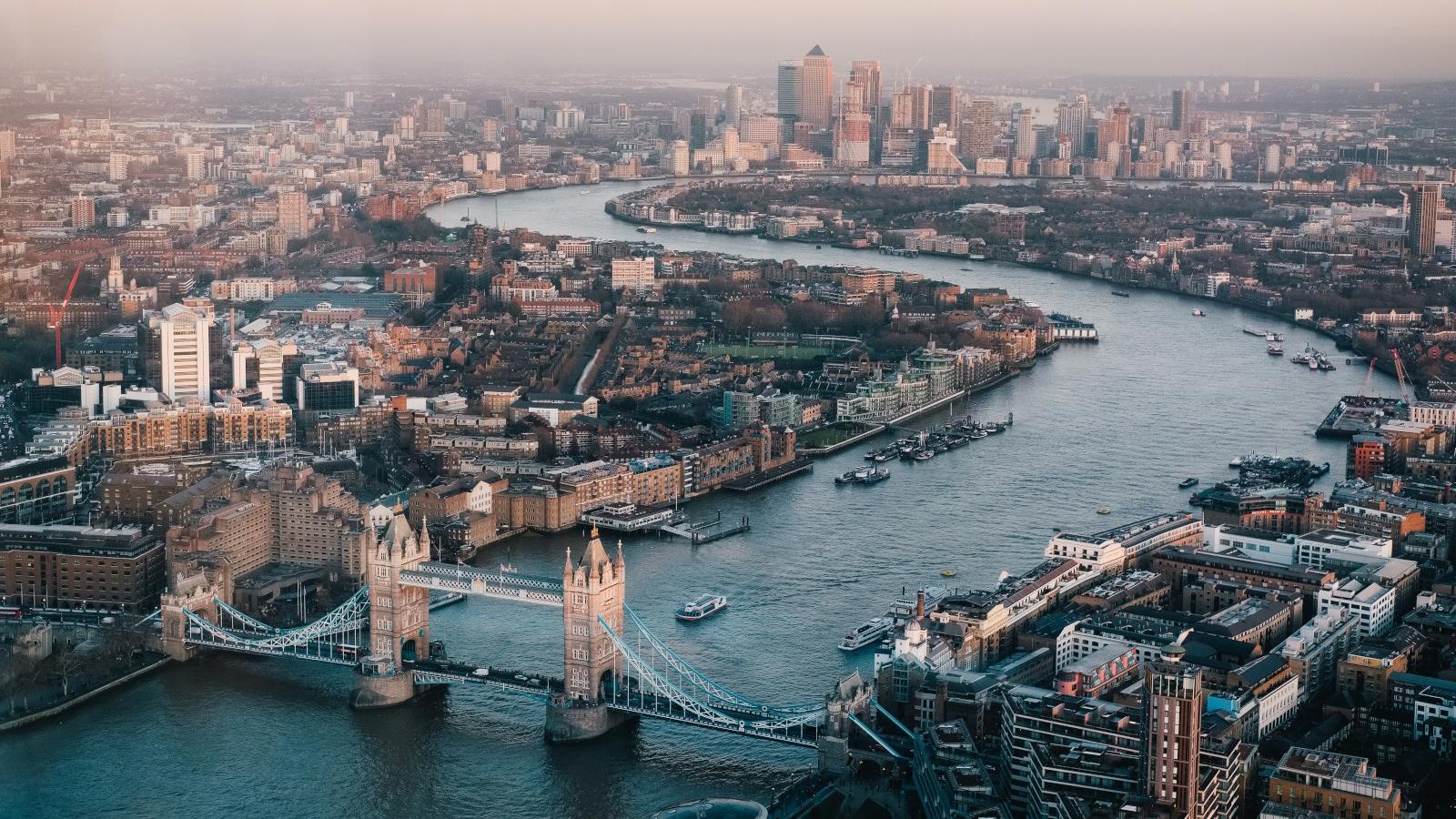 a bridge over a river with a city in the background