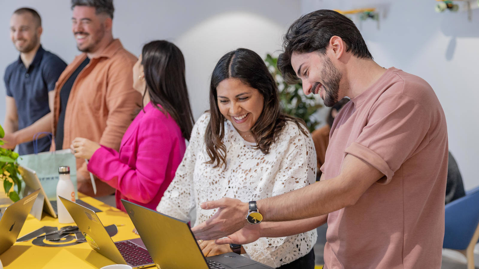 a group of people looking at laptops