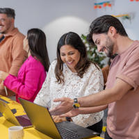 a group of people looking at laptops