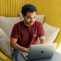a man sitting in a chair using a laptop