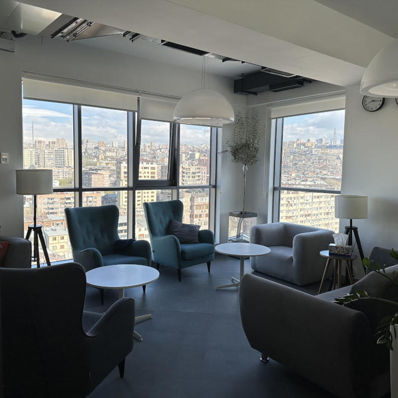 a room with chairs and tables and a large window