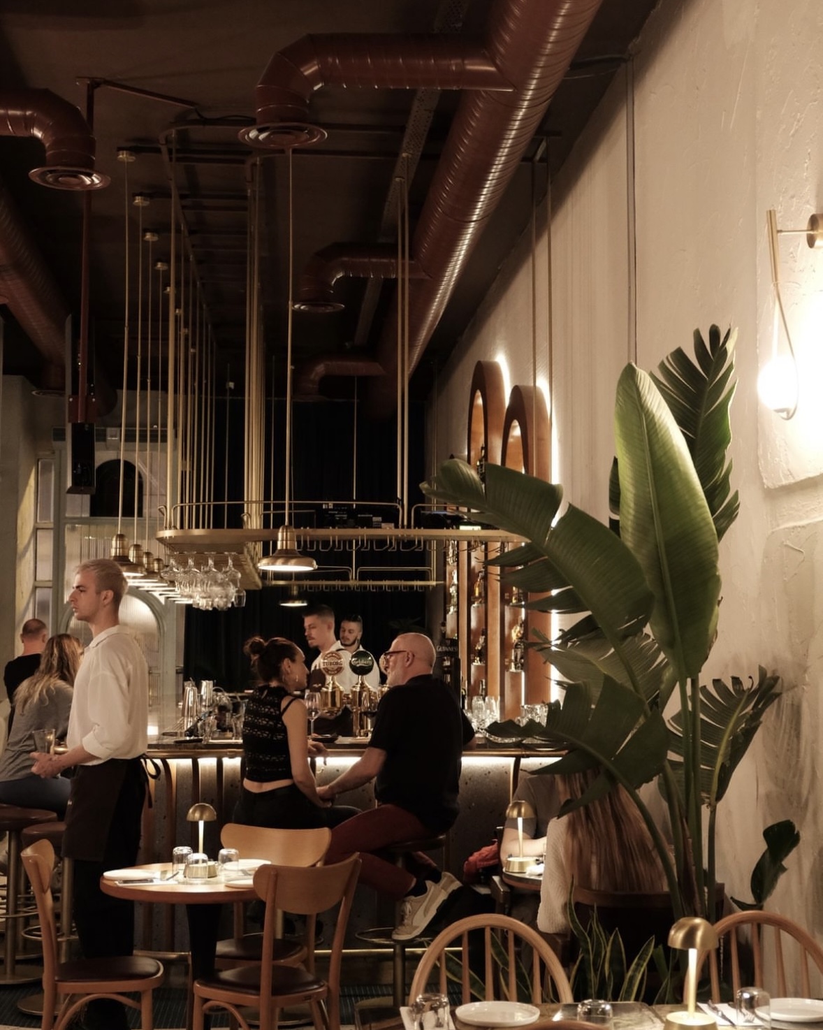 a group of people sitting at tables in a restaurant