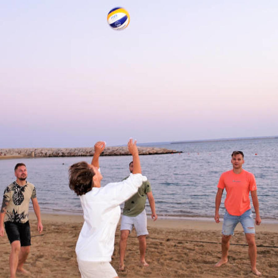 a group of men playing volleyball on a beach