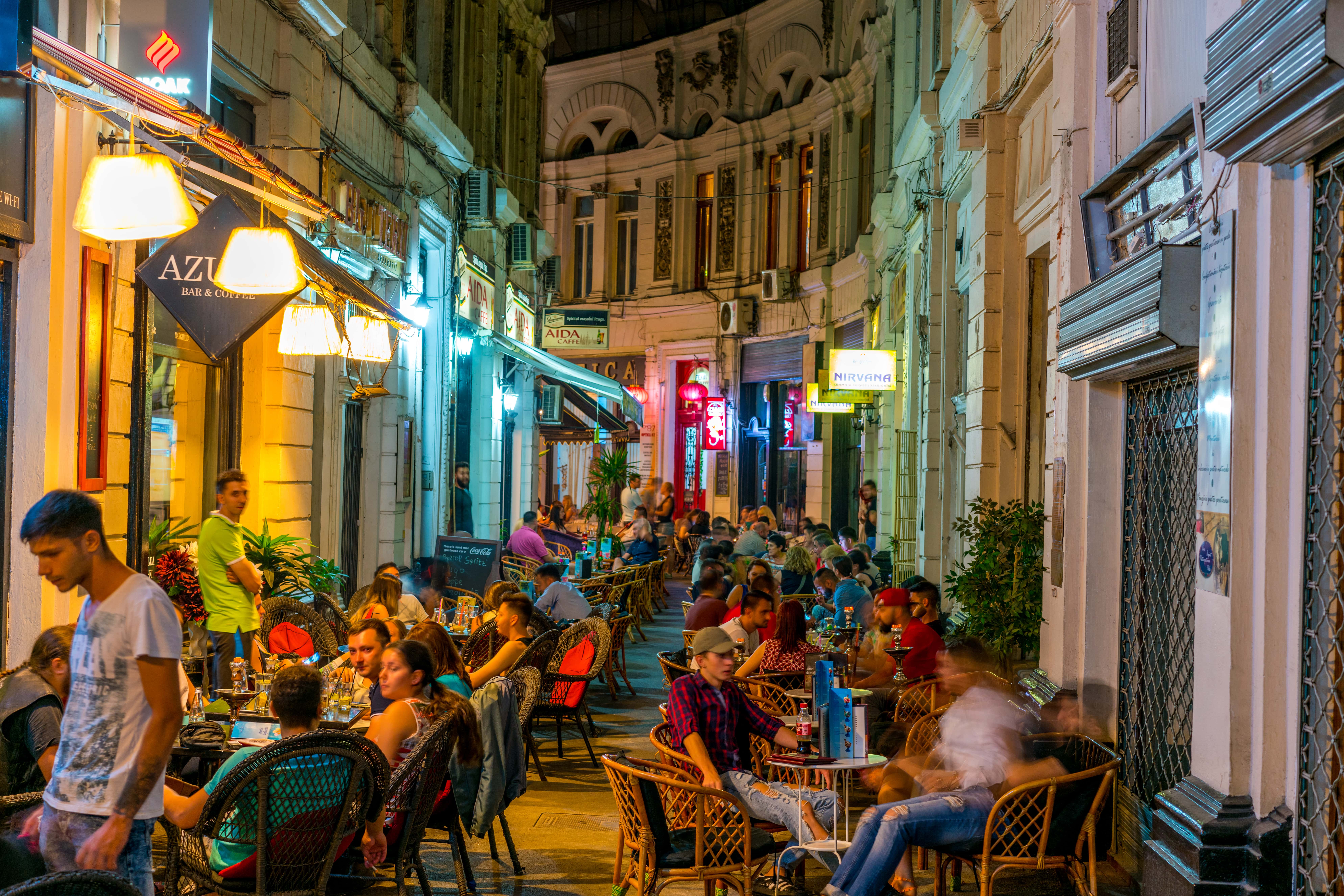a group of people sitting at tables in a street