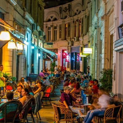 a group of people sitting at tables in a street