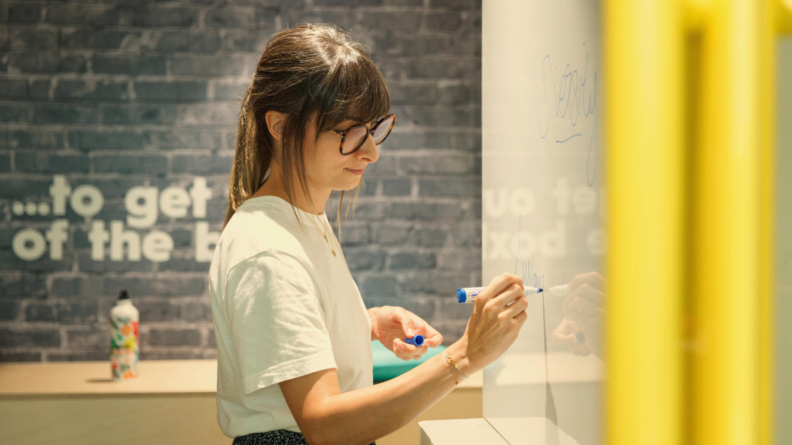 a woman writing on a white board