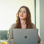 a woman sitting at a table with a laptop