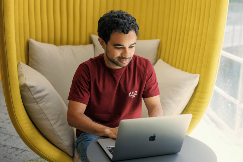 a man sitting in a chair using a laptop