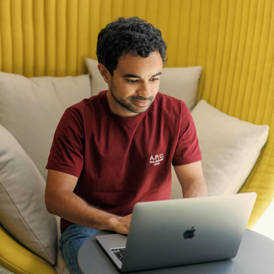a man sitting in a chair using a laptop