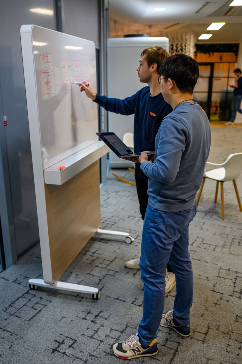 a man writing on a white board