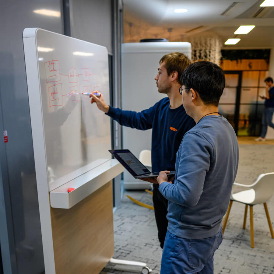 a man writing on a white board