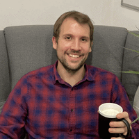 a man sitting on a couch holding a cup