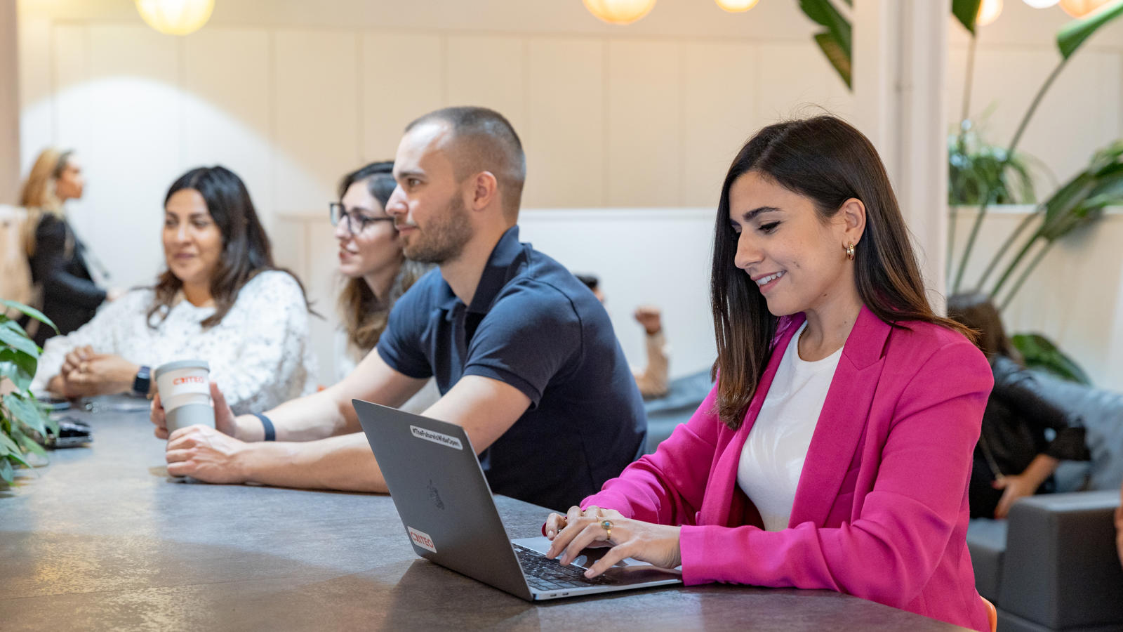 a group of people sitting at a table with a laptop