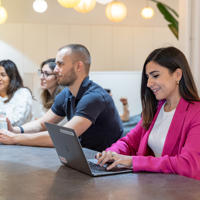 a group of people sitting at a table with a laptop