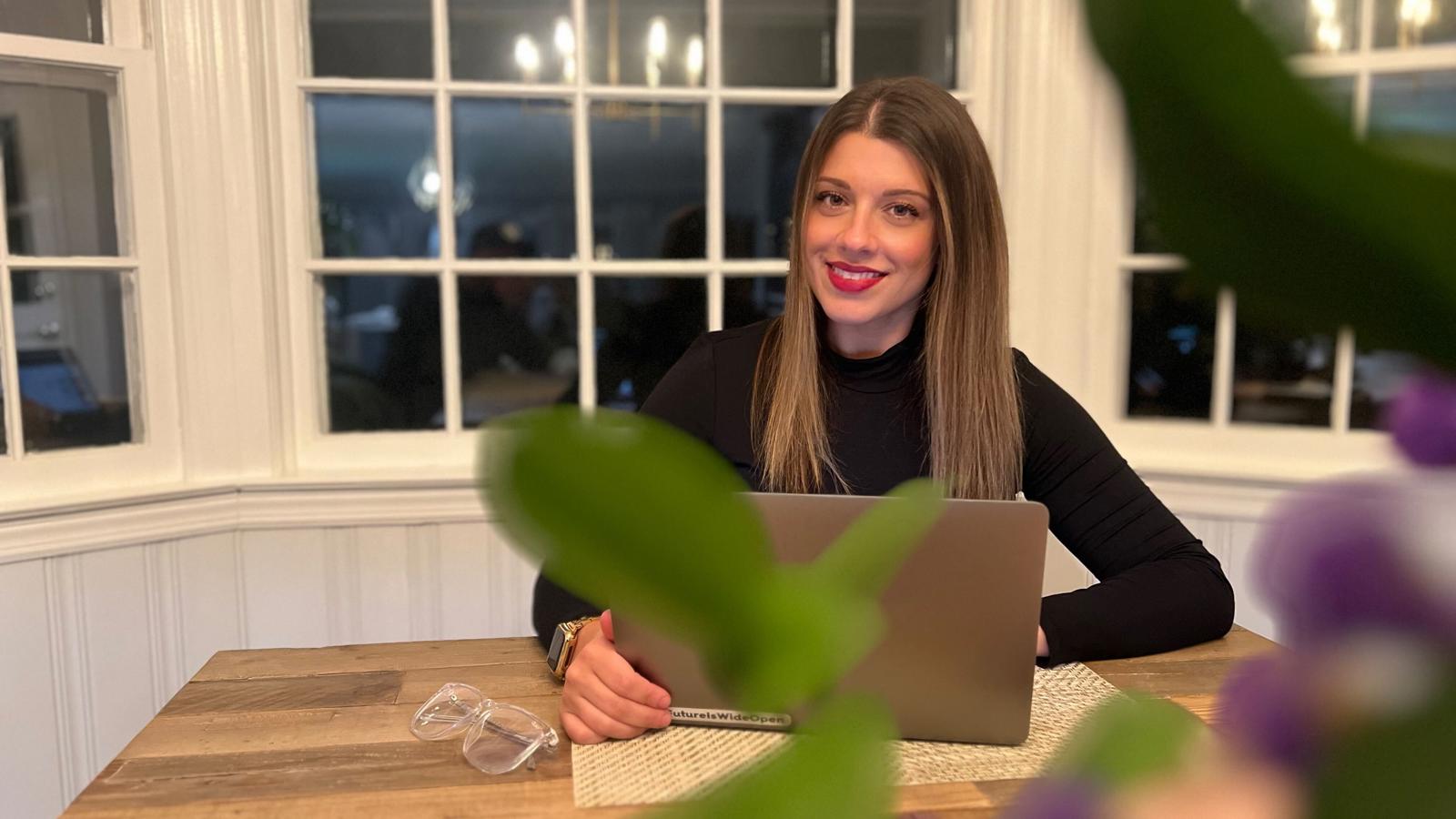 a woman sitting at a table with a laptop