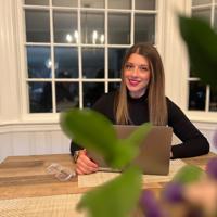 a woman sitting at a table with a laptop