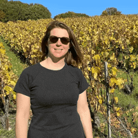 a woman standing in a vineyard