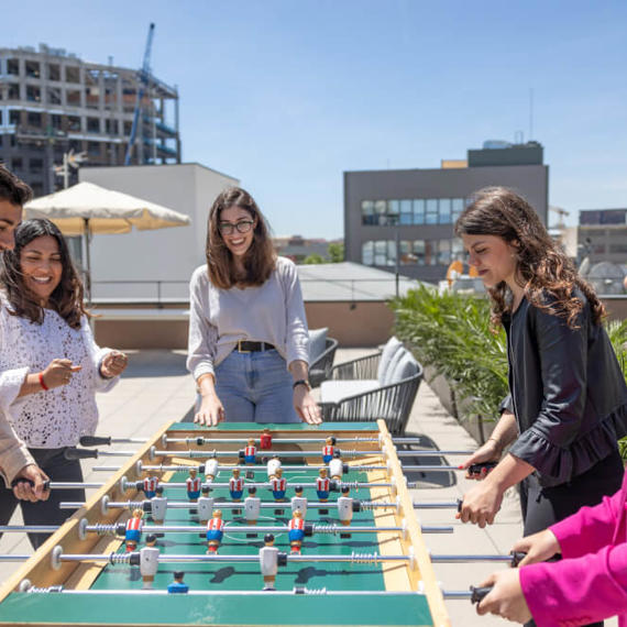 a group of people playing foosball on a rooftop