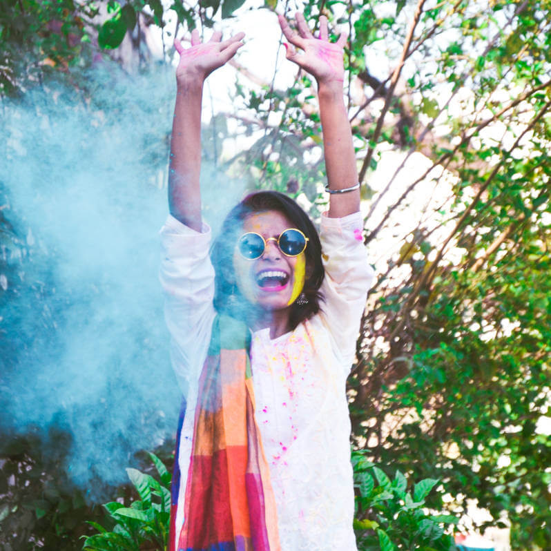 a woman with glasses and a scarf with paint on her face